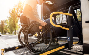 man in a wheelchair entering a vehicle on a ramp