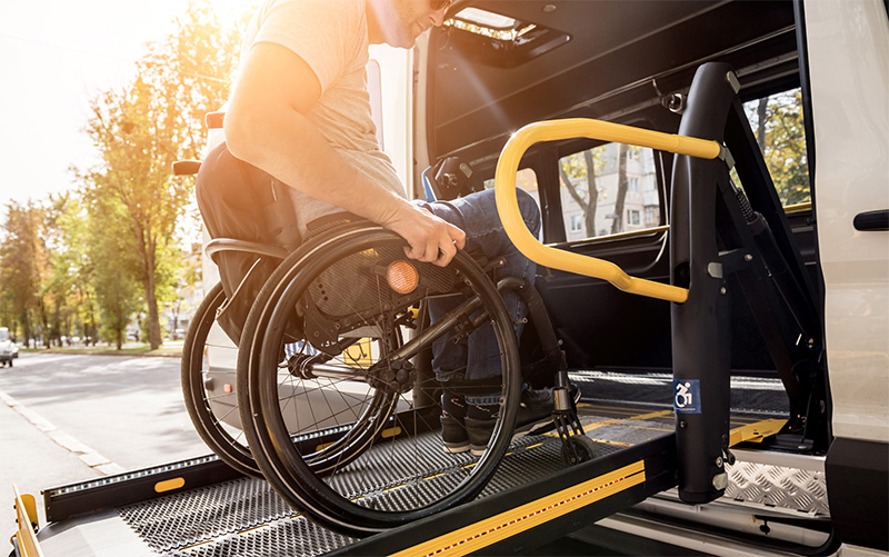 man boarding an accessible vehicle using wheelchair ramp
