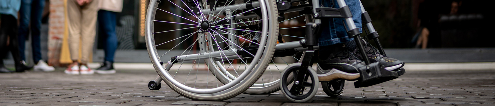 Close-up shot of man turning the wheels on his wheelchair.