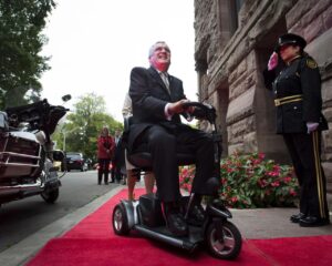 David Onley entering building using scooter.